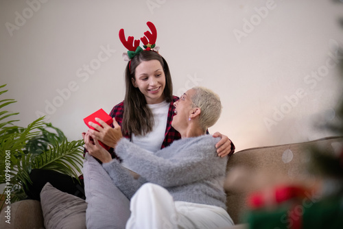 Intergenerational Holiday Bonding Daughter and Grandmother Exchanging Gifts photo