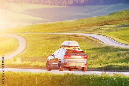 Car with roofbox on winding rural road photo