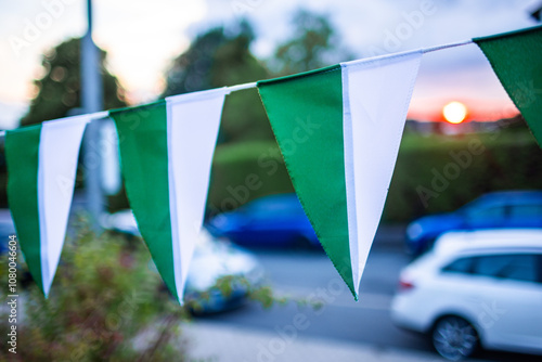 Grün-weiße Wimpel auf einem Schützenfest vor einem Sonnenuntergang