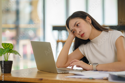 Bild auf Leinwand Beautiful Asian businesswoman using a laptop working in an office and depressed