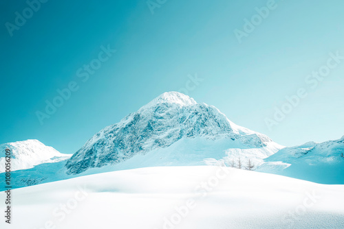 Winter landscape. Snowy mountain peak under clear blue sky