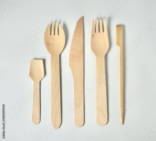 Set of bamboo wooden kitchenware eating utensil spoon, spork, fork, knife, and skewer stick object with no food isolated on horizontal white background.