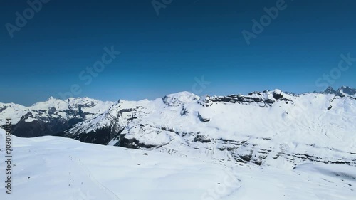 Aerial drone view of Grand Massif area within sight of Mont Blanc, France. Snowy winter in French Alps, ski resort Flaine. Drone going forward. Clear blue sky. Winter landscape. photo