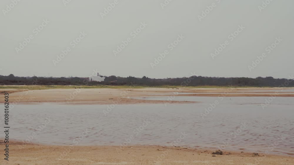 Low Water Levels in Riverbed: Drought and Environmental Impact. Low water levels, exposing sandy and barren patches. A sense of vulnerability in natural resources Low Water Levels in Riverbed: Drought and Environmental Impact. Low water levels, exposing sandy and barren patches. A sense of vulnerability in natural resources