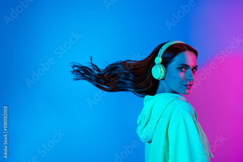 Photo of charming positive woman wear green sweatshirt headphones enjoy songs wind blowing isolated neon blue color background photo