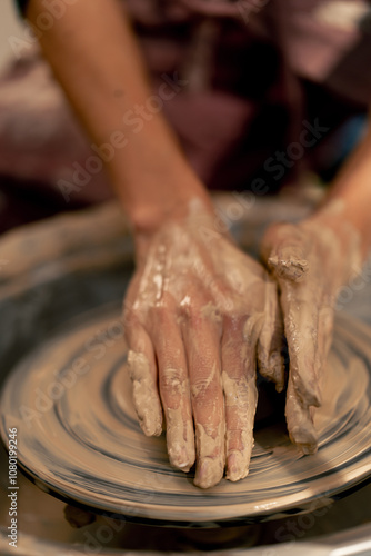 close up the clay modeling studio young girl hands giving shape to clay on a potter's wheel applied art clayware old craftsmanship teacher helps