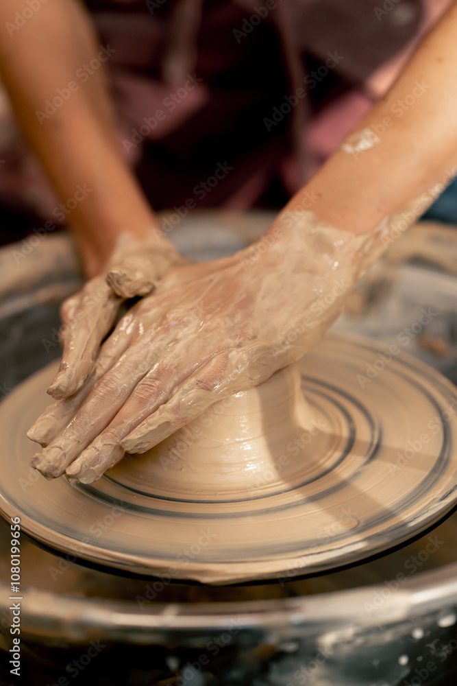 close up the clay modeling studio young girl hands giving shape to clay on a potter's wheel applied art clayware old craftsmanship teacher helps close up the clay modeling studio young girl hands giving shape to clay on a potter's wheel applied art clayware old craftsmanship teacher helps