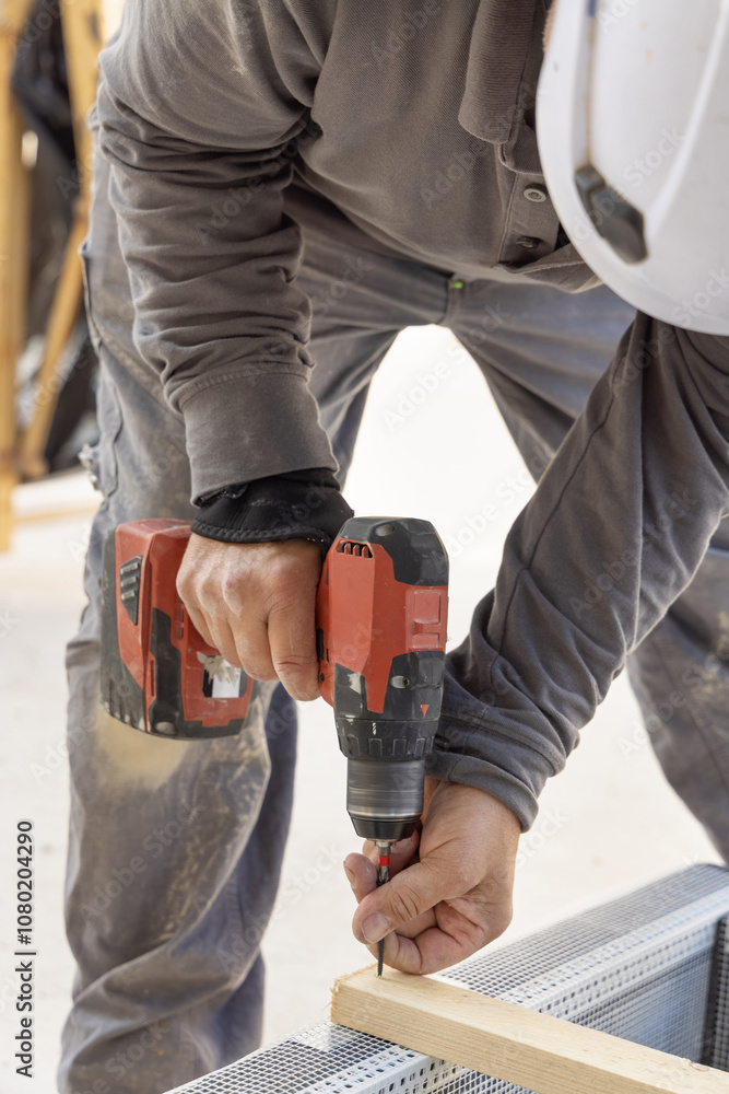 Carpenter working on wooden board using professional electric cordless screwdriver Carpenter working on wooden board using professional electric cordless screwdriver