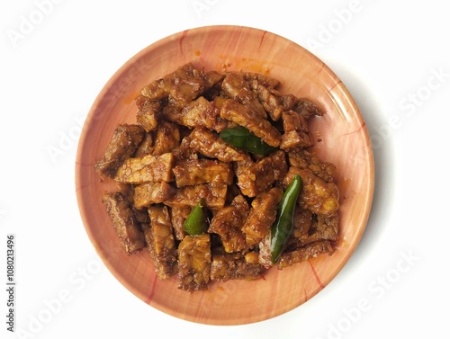 Oreg tempe or Indonesian food made from tempeh with soy sauce and spices on plate isolated on white background  photo