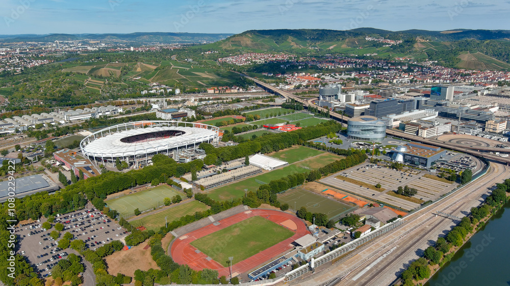 Fototapeta premium Stuttgart’s sports stadium surrounded by green hills and vineyards, offering a picturesque view of city planning and nature