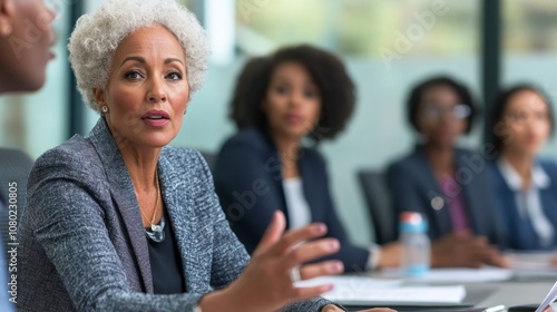 A woman in a gray jacket is talking to a group of women