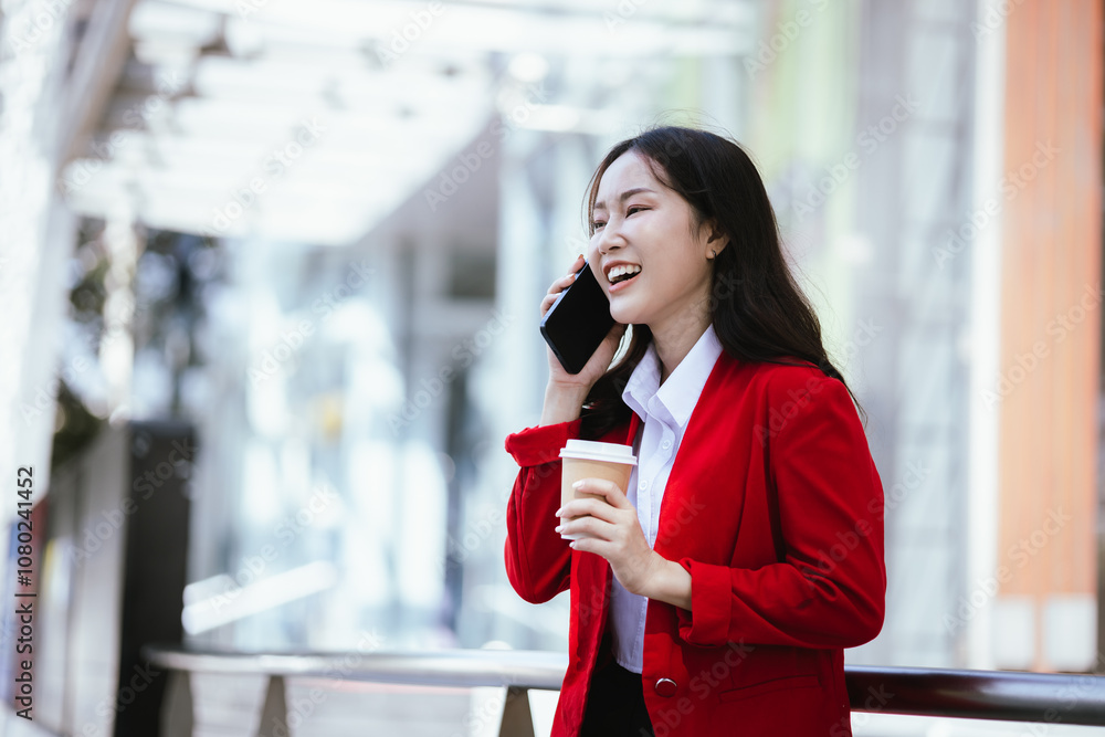 Stylish Asian businesswoman standing confidently in an urban setting holding a tablet. She is dressed in a professional business suit, demonstrating modern leadership and corporate success. Stylish Asian businesswoman standing confidently in an urban setting holding a tablet. She is dressed in a professional business suit, demonstrating modern leadership and corporate success.