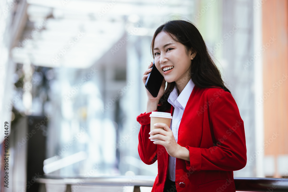Stylish Asian businesswoman standing confidently in an urban setting holding a tablet. She is dressed in a professional business suit, demonstrating modern leadership and corporate success. Stylish Asian businesswoman standing confidently in an urban setting holding a tablet. She is dressed in a professional business suit, demonstrating modern leadership and corporate success.