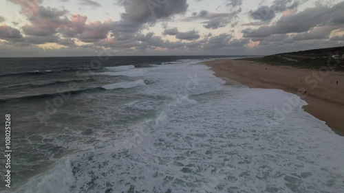 drone survolant les vagues et la plage de Nazare en automne pedant le sunset