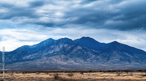 A large mountain with a few clouds in the sky, great for use in travel or outdoor themed projects