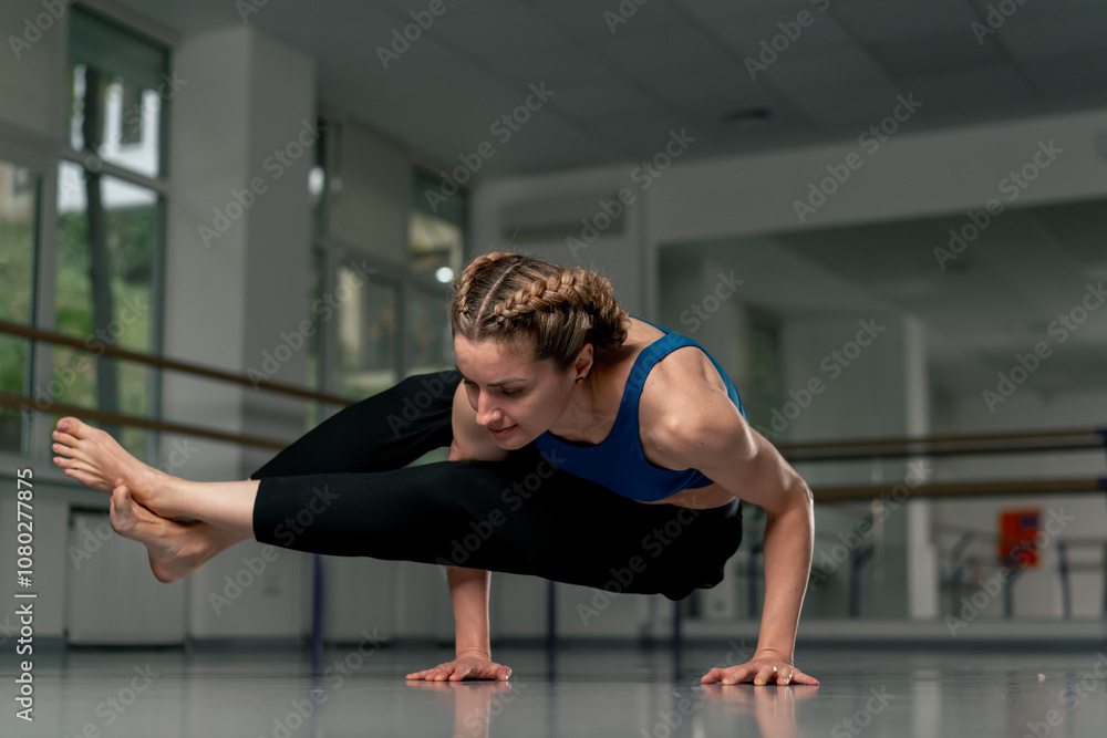 in the studio of spiritual development master class in yoga middle-aged girl in blue top and pants in a bright room pose asana strength exercises emphasis on arms in the studio of spiritual development master class in yoga middle-aged girl in blue top and pants in a bright room pose asana strength exercises emphasis on arms