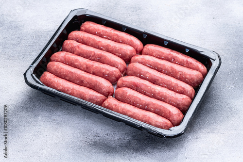 Raw beef sausages with rosemary and tomatoes photography . Top view