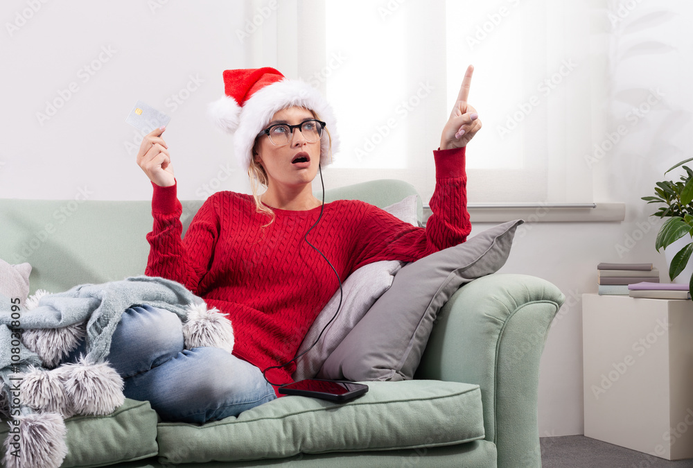 A woman sits comfortably on her couch at home, using her smart glasses to browse the internet for Christmas shopping, while using her credit card to make purchases and payments through her smartphone A woman sits comfortably on her couch at home, using her smart glasses to browse the internet for Christmas shopping, while using her credit card to make purchases and payments through her smartphone
