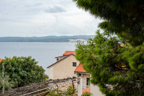 Sunny day view of the Adriatic Sea over red-tiled rooftops in Stanici, Croatia, capturing coastal charm. photo