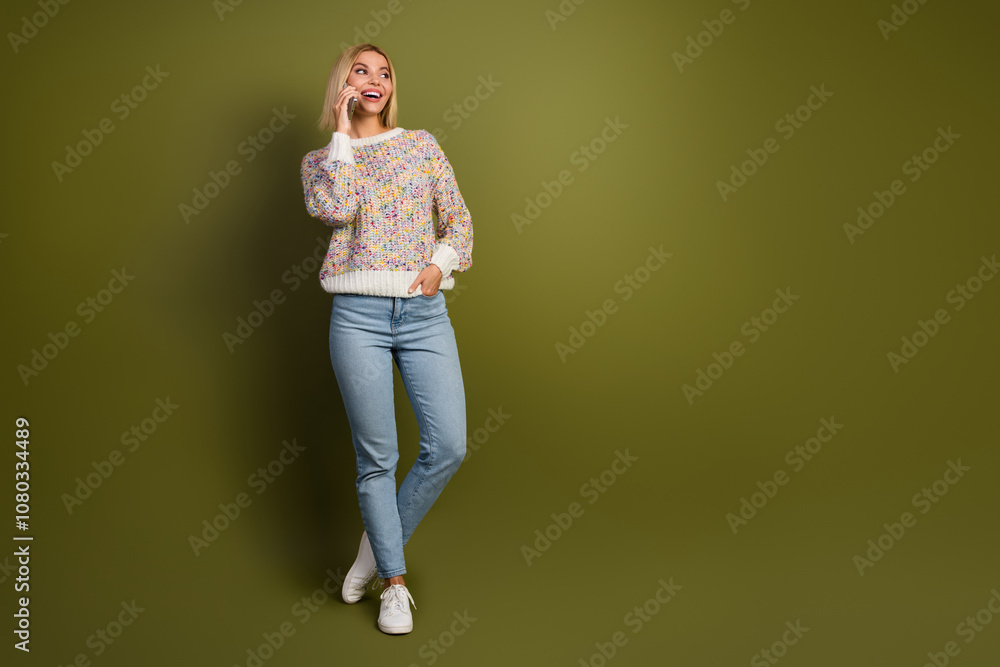 Cheerful young woman in colorful sweater standing against khaki background, casually chatting and expressing joy, embodying fashion and positive lifestyle concepts Cheerful young woman in colorful sweater standing against khaki background, casually chatting and expressing joy, embodying fashion and positive lifestyle concepts