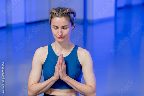 in the spiritual development studio master class in yoga middle-aged girl in a blue top and pants in bright room pose asana strength exercises handstand only