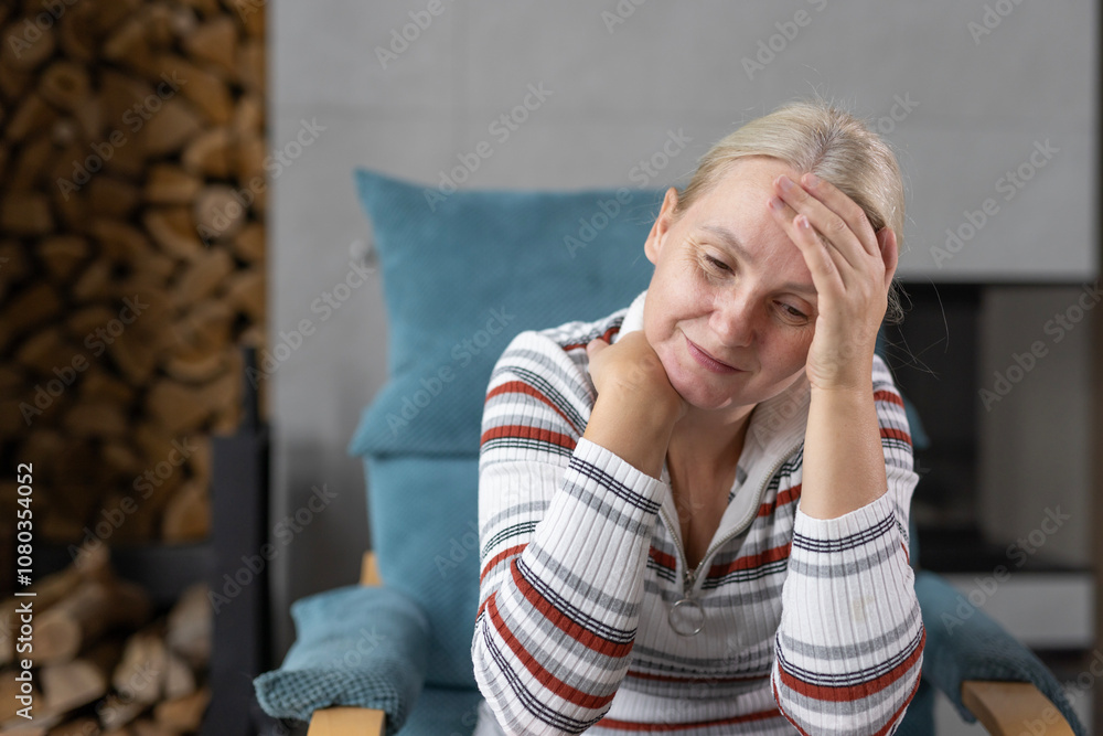 Middle-aged woman resting her head on her hand, sitting indoors with a thoughtful and serene expression, in a relaxed atmosphere. Middle-aged woman resting her head on her hand, sitting indoors with a thoughtful and serene expression, in a relaxed atmosphere.
