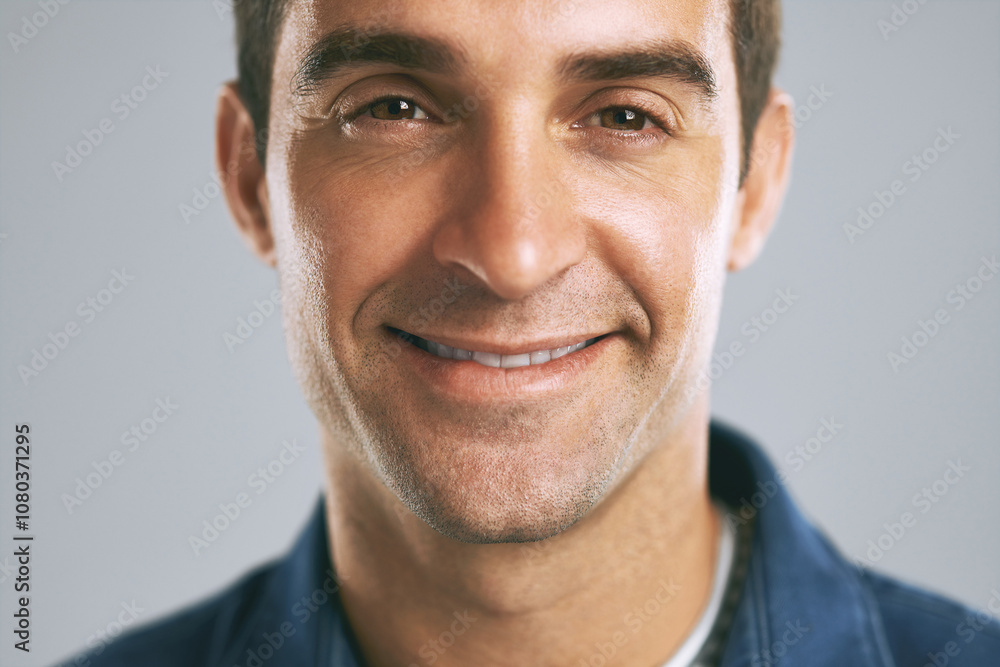 Fototapeta premium Man, face and happy in studio for positive attitude, confidence and pride with gray background. Male person, portrait and employee for creative agency, design and career growth with smile in Madrid