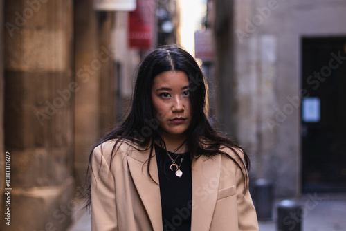 Portrait of a confident young asian businesswoman walking down a city street