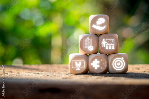 Wooden blocks with career-related icons symbolize goals, teamwork, and success, set against a natural background. photo