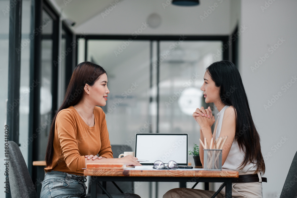 Two women chatting in a contemporary office, fostering collaboration and teamwork. Ideal for business and communication themes. Two women chatting in a contemporary office, fostering collaboration and teamwork. Ideal for business and communication themes.