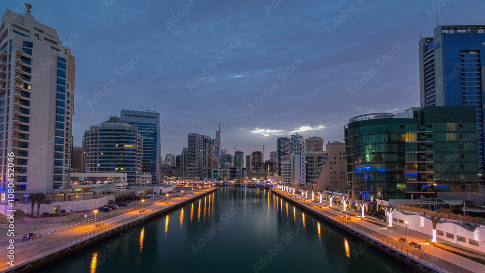 Naklejka premium Dubai Marina towers and canal in Dubai night to day timelapse