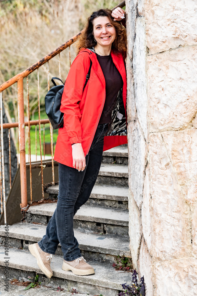 woman with brown hair and a red jacket is smiling