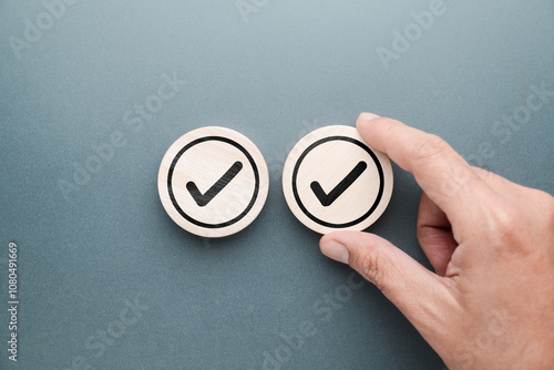 Hand adds another piece of wood with correct check mark in it, Double-Check concept