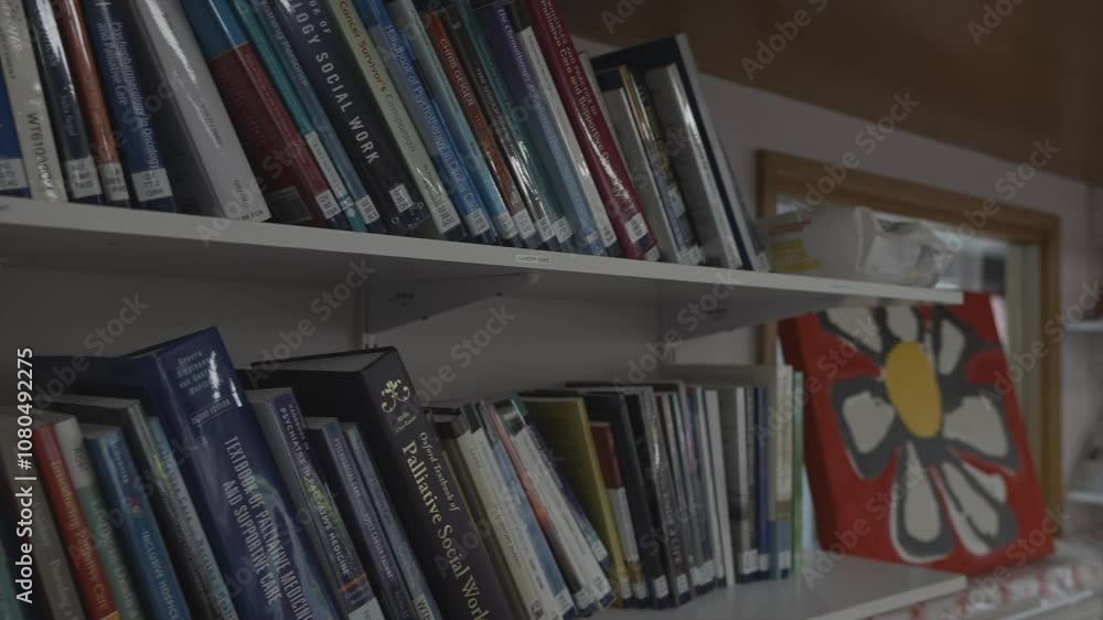A bookcase with many books on it. The books are arranged in a way that they are easy to access A bookcase with many books on it. The books are arranged in a way that they are easy to access