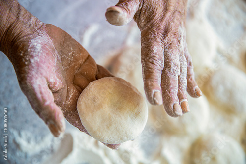 Woman chef preparing dough makes the cheesecakes in the kitchen, closeup. Process of working with the dough at home. Cookie dough for baking, pieces of raw dough photo