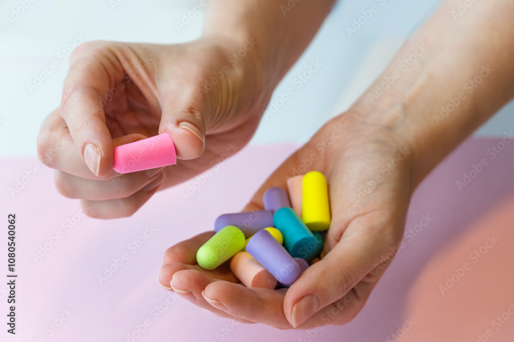 group of colorful ear plugs noise reduction sleep quiet jar, woman's hands holding earplugs group of colorful ear plugs noise reduction sleep quiet jar, woman's hands holding earplugs