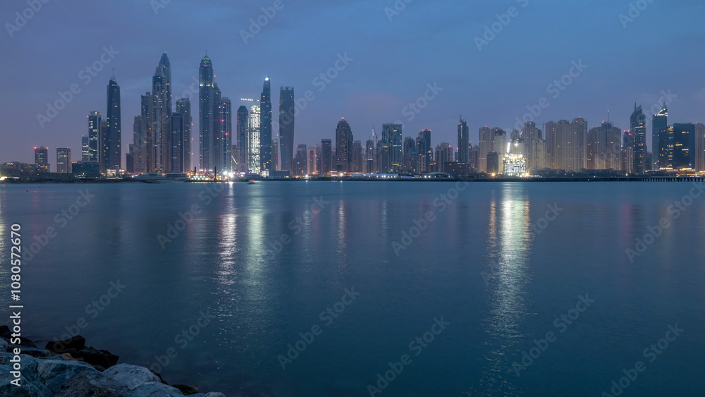 Panorama of modern skyscrapers in Dubai city night to day timelapse from the Palm Jumeirah Island. Panorama of modern skyscrapers in Dubai city night to day timelapse from the Palm Jumeirah Island.