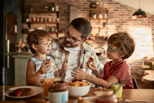 Father enjoying breakfast time with two young sons in cozy kitchen photo