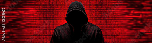 Mysterious figure in a dark hoodie with a blurred red background, symbolizing anonymity and digital secrecy. Perfect for themes of technology.