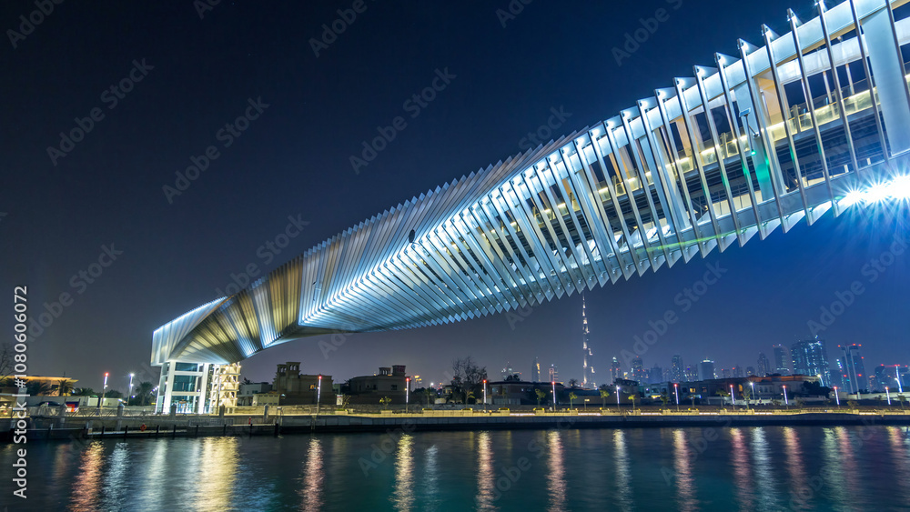 Fototapeta premium Futuristic Pedestrian Bridge over the Dubai Water Canal Illuminated at Night timelapse hyperlapse, UAE.