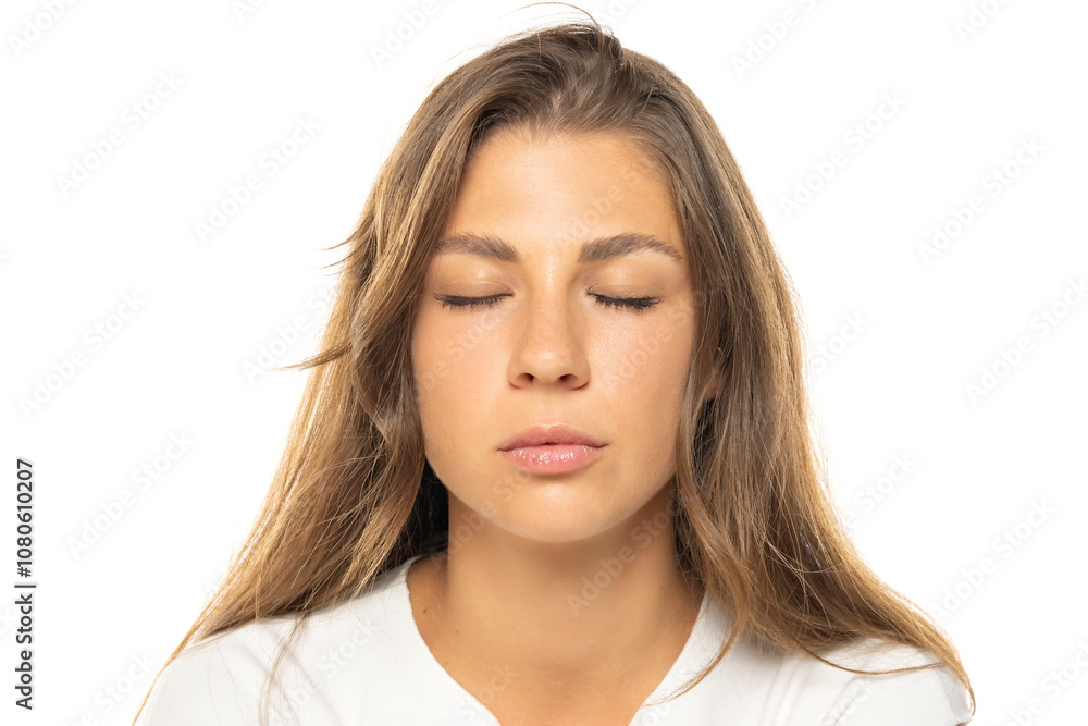 Portrait of a young beautiful woman posing with closed eyes on a white studio background. Portrait of a young beautiful woman posing with closed eyes on a white studio background.