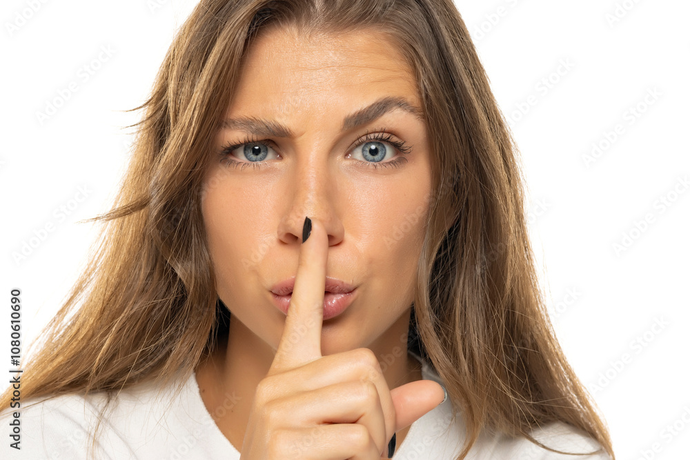 Portrait of a serious young woman showing silence gesture. Portrait of a serious young woman showing silence gesture.