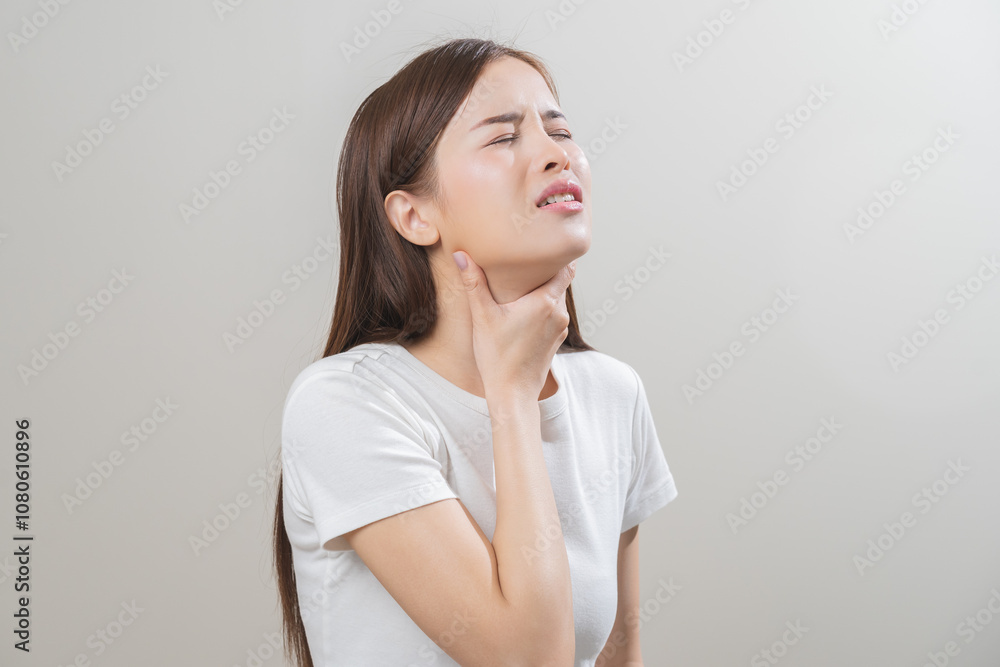 Sickness in inflaming asian young woman, girl use hand check self touch at sore throat, pain thyroid gland on neck or disease reflux, acid of suffer people on wall background. Medical and healthcare. Sickness in inflaming asian young woman, girl use hand check self touch at sore throat, pain thyroid gland on neck or disease reflux, acid of suffer people on wall background. Medical and healthcare.