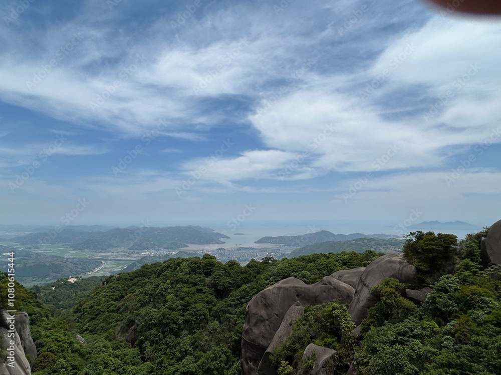 View from the Mountain Top Overlooking the Landscape with Blue Sky and White Clouds View from the Mountain Top Overlooking the Landscape with Blue Sky and White Clouds