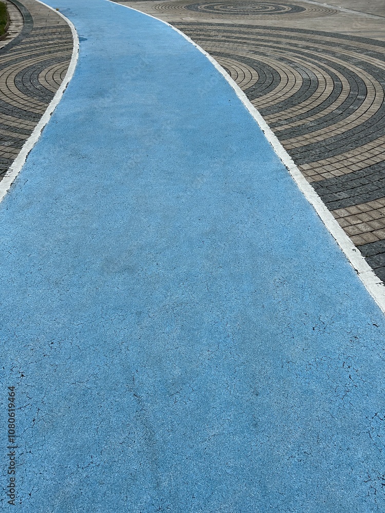 Fototapeta premium Blue Walking Path with Circular Stone Paved Plaza in the Center