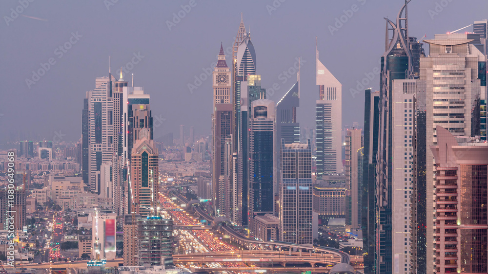 Obraz premium Aerial view to skyscrapers on Dubai downtown and Sheikh Zayed road day to night timelapse, Dubai, United Arab Emirates