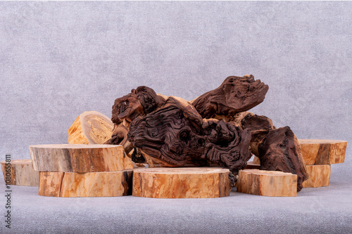 Empty wooden podium, pieces of snag of Mopani tree on grey background. Minimalist eco backdrop. Round natural wooden cross sections and snags. Copy space, front view. photo