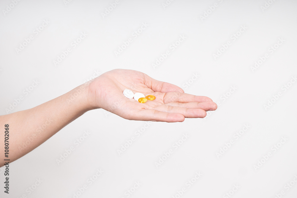 Woman hands taking multiple pills , vitamins D3 and Zinc, daily supplement vitamins isolated on white background Woman hands taking multiple pills , vitamins D3 and Zinc, daily supplement vitamins isolated on white background