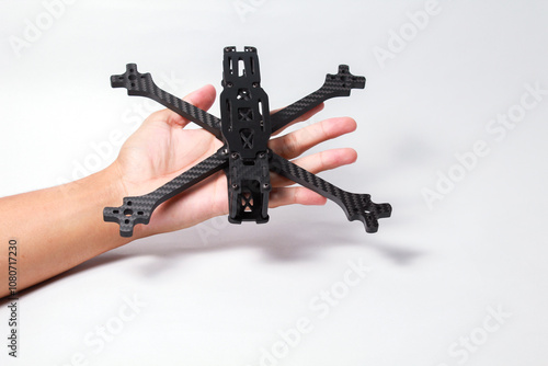 Male hand holding 5 Inch FPV drone frame, made fully from carbon fibre