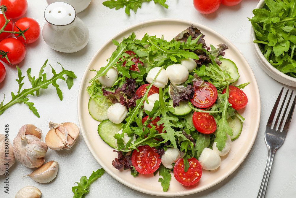 Tasty salad with arugula, lettuce, mozzarella cheese, vegetables and fork on white table, flat lay Tasty salad with arugula, lettuce, mozzarella cheese, vegetables and fork on white table, flat lay